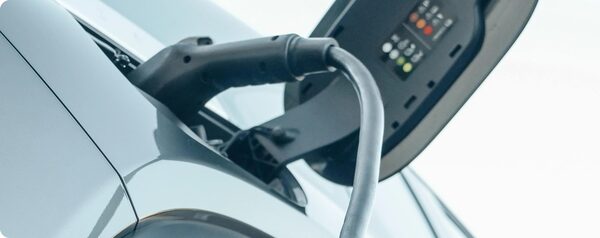 A charging cable plugged into the charging port of an electric car