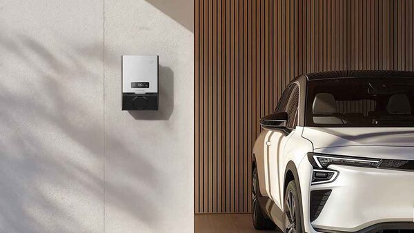 An EcoFlow PowerPulse 2 wall-mounted EV charger next to a parked white electric car