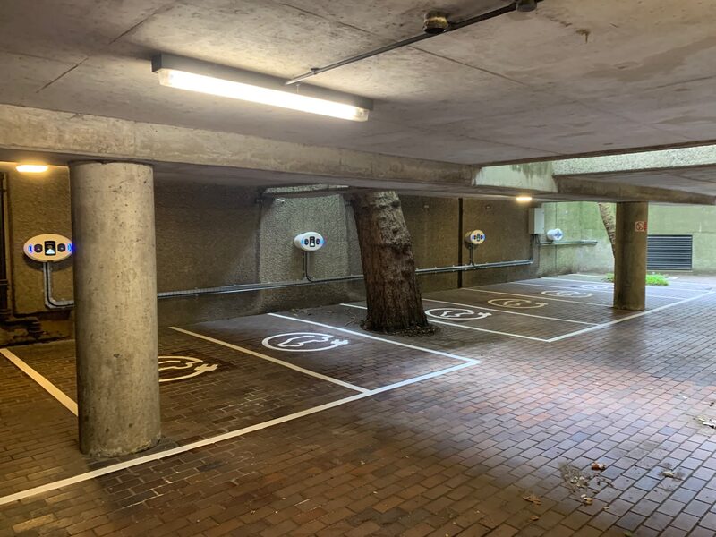 Wall-mounted EV charge points in an undercroft car park with marked electric-vehicle parking bays