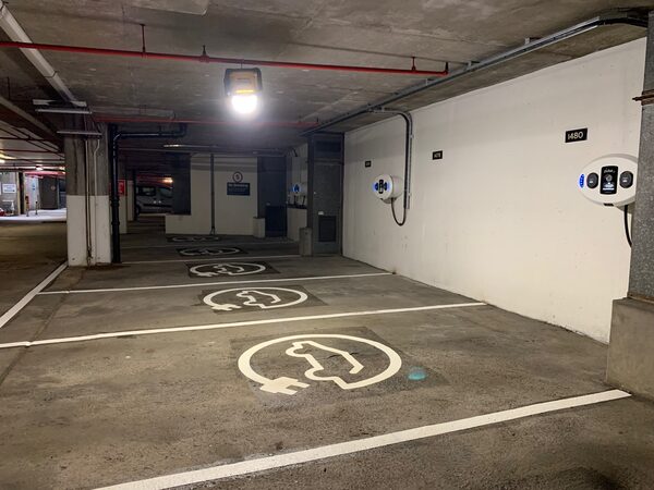 Wall-mounted EV charge points in an underground car park with electric-vehicle parking bay markings on the floor