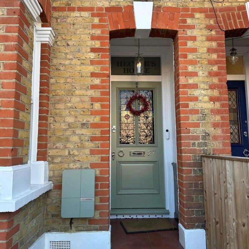 An Andersen EV charger mounted on the brick wall beside the front door of a Victorian terraced house