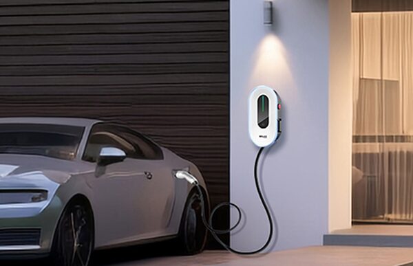 A wall-mounted SolaX EV charge point on a house exterior charging a silver car
