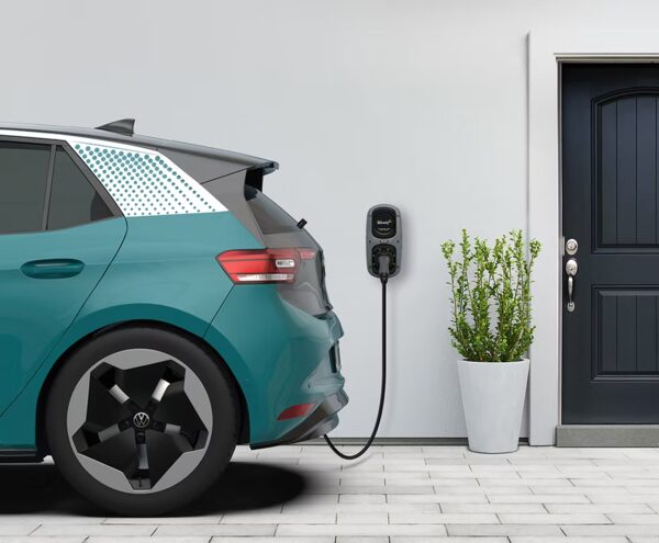A teal Volkswagen ID.3 electric car charging from a wall-mounted Rolec WallPod EV charger outside a house door