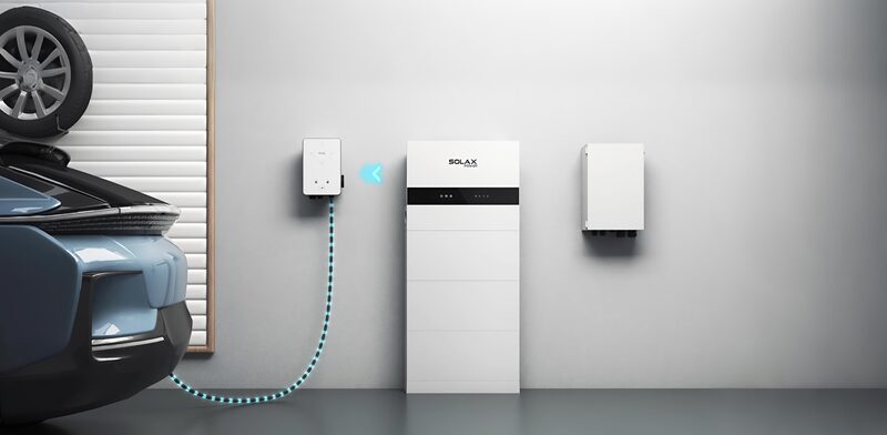 A SolaX home battery storage unit and wall-mounted charger installed in a garage next to an electric car