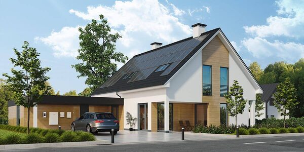 A modern house with rooftop solar panels, an Audi estate car parked outside and a wall-mounted battery/inverter unit on the garage wall