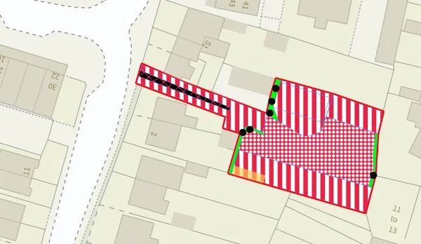 A planning map of a small development site with red-outlined boundaries and hatched red-and-white areas marking the site extent
