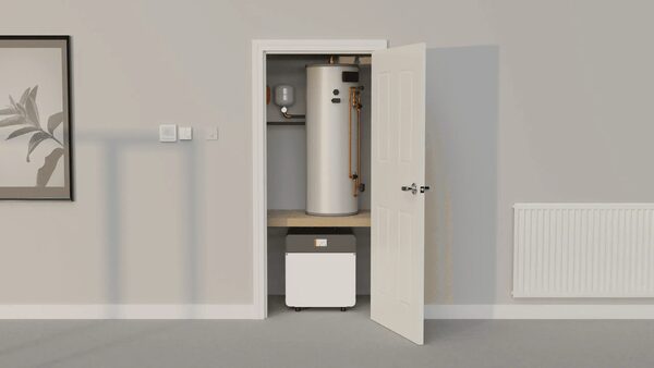 A ground source heat pump unit and hot water cylinder installed inside a household airing cupboard with the door open