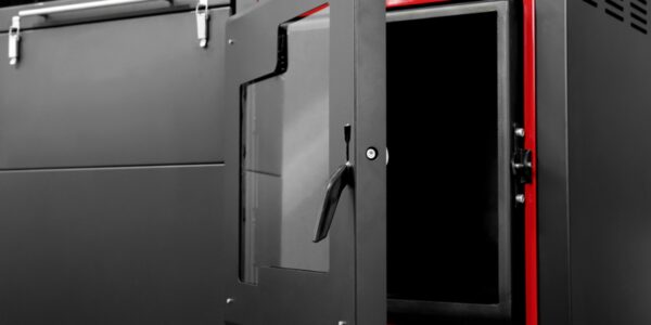 A close-up of a grey and red biomass boiler with its glass door open