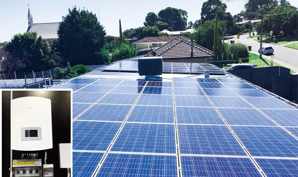 A large rooftop solar panel installation on a suburban house with an inset photo of a wall-mounted solar inverter