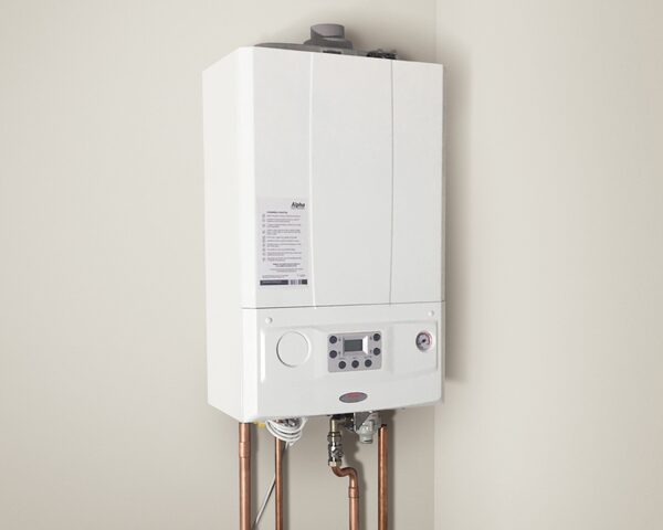 A white Alpha wall-mounted combi boiler installed on a plain wall with copper pipework below