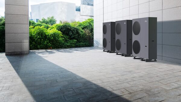 Three large grey Ferroli OMNIA air source heat pump units standing outside against a tiled wall