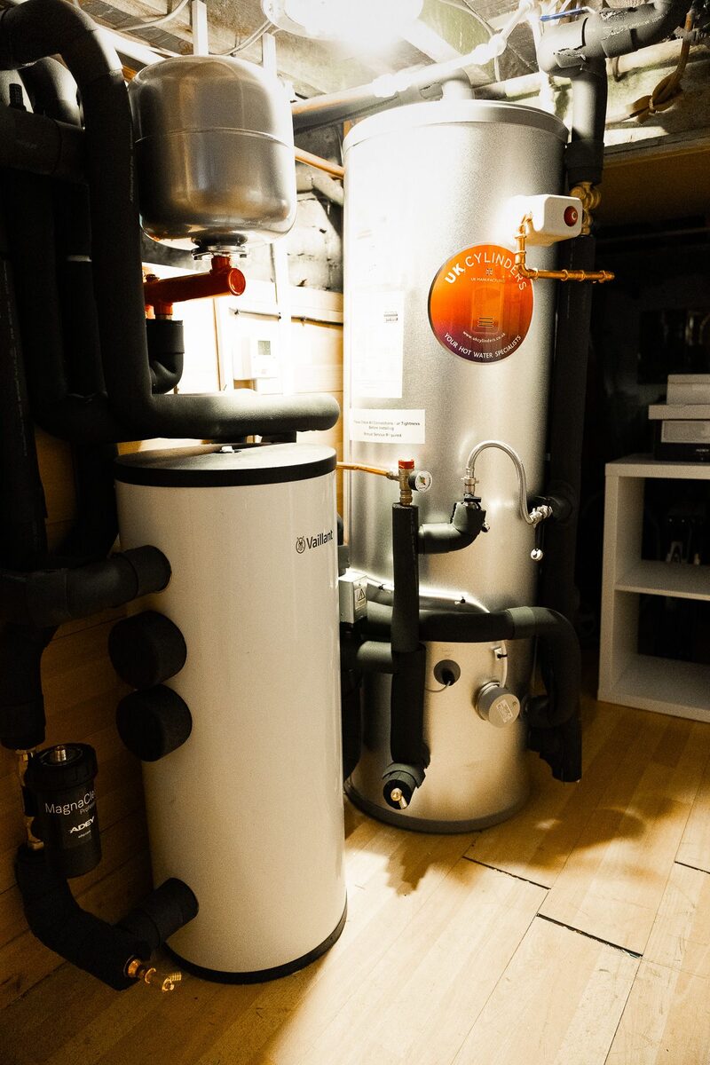 A Vaillant hot water cylinder and buffer tank with insulated pipework installed in a home plant room