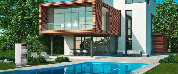 A Heliotherm air source heat pump unit installed in the garden beside a modern house with a swimming pool