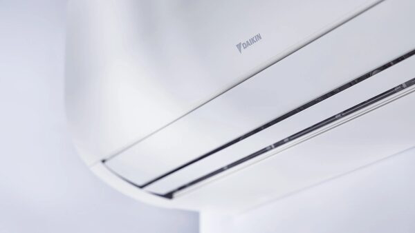 A close-up of a white Daikin wall-mounted air-to-air heat pump indoor unit