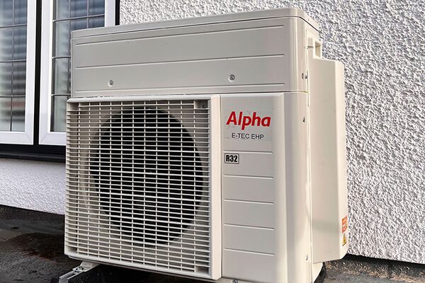 An Alpha E-TEC EHP air source heat pump unit installed outside a house wall next to a window