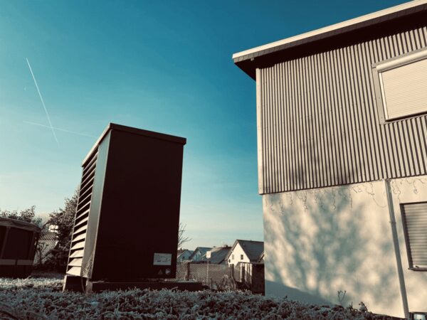 An outdoor heat pump unit installed beside a house on a frosty morning