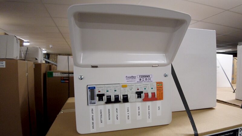 A FuseBox F2006MX consumer unit with labelled heat pump circuit breakers, photographed in a warehouse