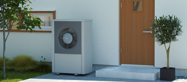 An IVT AirX air source heat pump outdoor unit installed beside the front door of a house