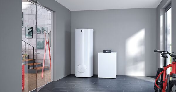 A Viessmann ground source heat pump indoor unit with a white cylindrical hot water cylinder installed in a modern grey utility room