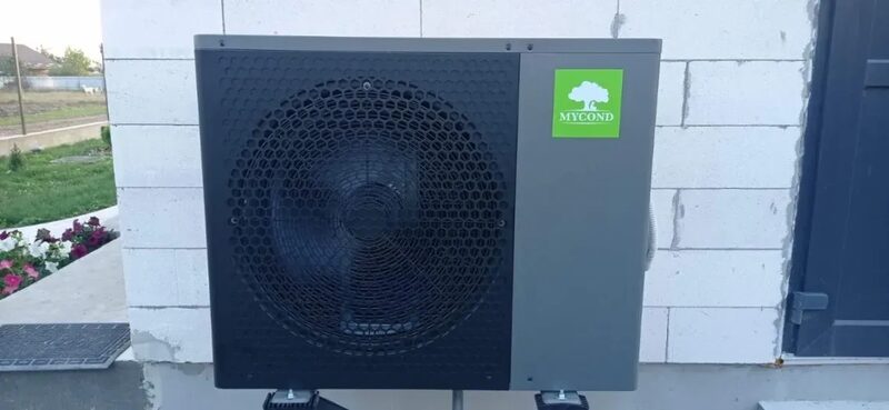 A Mycond air source heat pump unit mounted on the exterior wall of a house