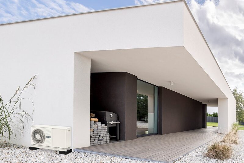 A Hitachi air source heat pump unit installed outside a modern white house