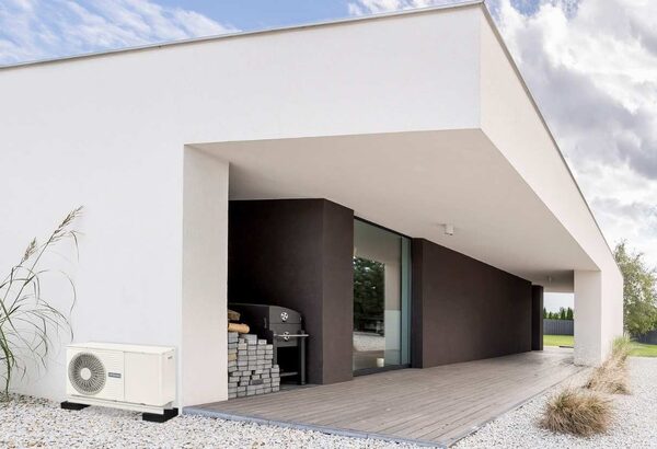 A Hitachi air source heat pump unit installed outside a modern white house