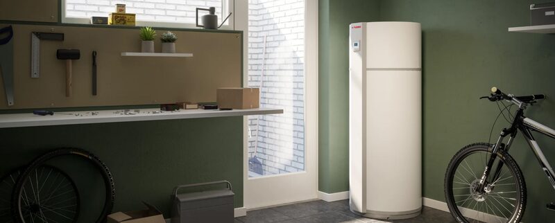 A white NIBE hot water heat pump cylinder installed in a utility room or garage next to a bicycle and workbench