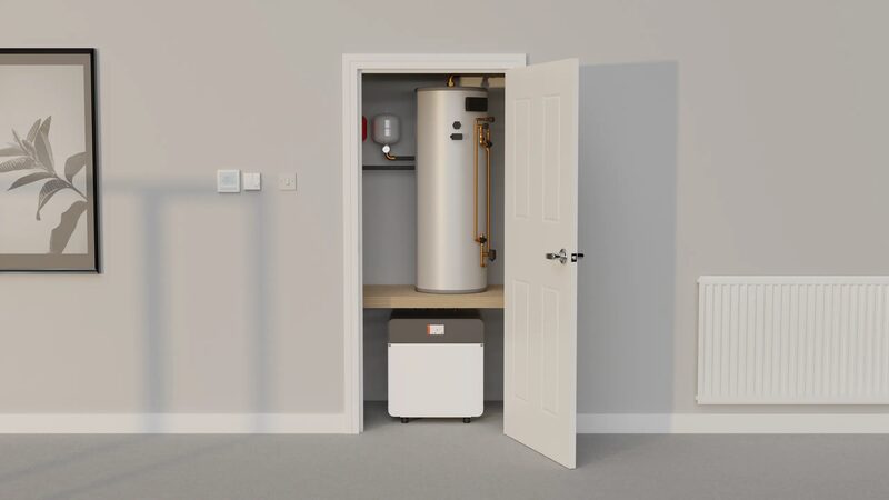 A Kensa ground source heat pump unit and hot water cylinder installed in a home airing cupboard with the door open