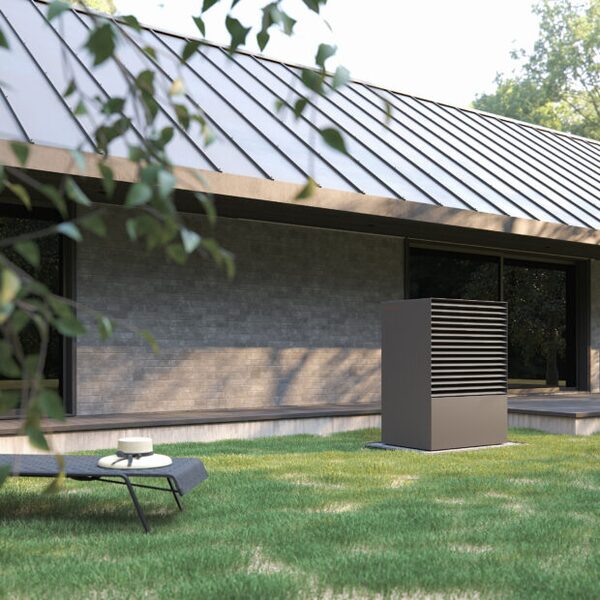 A Kronoterm air source heat pump unit installed on the lawn outside a modern single-storey house