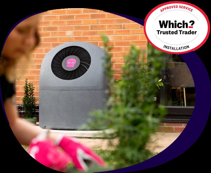 A Cosy air source heat pump installed outside a brick house, with a Which? Trusted Trader approved service badge overlaid