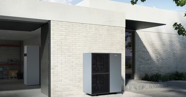 A Viessmann air source heat pump unit installed outside a modern white brick house