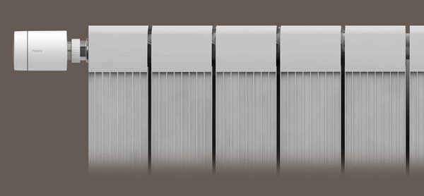 A white Aqara smart radiator thermostat valve fitted on the side of a white panel radiator