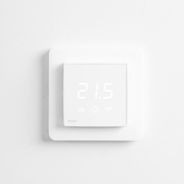 A white square wall-mounted digital thermostat displaying 21.5 degrees