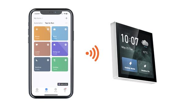 A smartphone app with Tap-to-Run scene tiles wirelessly paired to a wall-mounted smart touch-screen control panel showing the time and heating modes