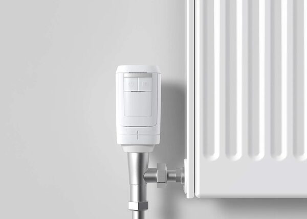 A white Honeywell Home wireless smart radiator valve (HR91) fitted to the valve of a white panel radiator