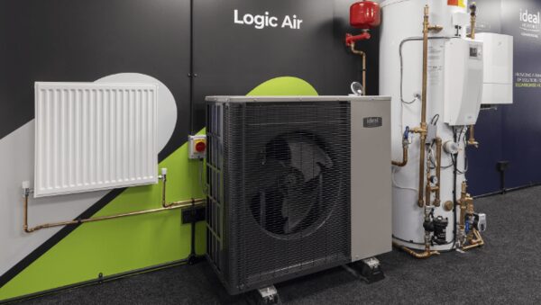 An Ideal Logic Air air source heat pump displayed with a radiator and hot water cylinder in a showroom setting