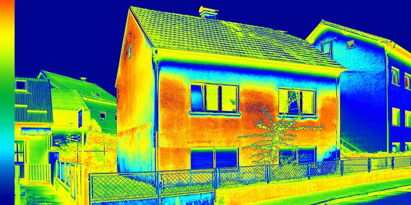 Thermal image of a house showing heat loss through its walls and roof