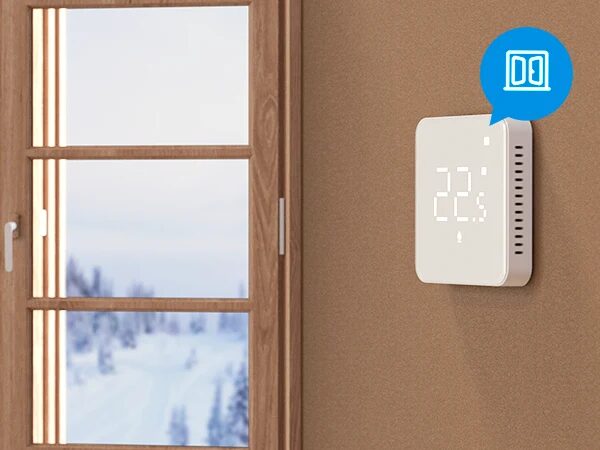 A white Meross smart thermostat mounted on a wall next to a window, displaying 22.5 degrees with an open-window icon