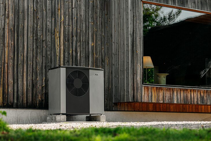 A NIBE air source heat pump unit installed outside a timber-clad house