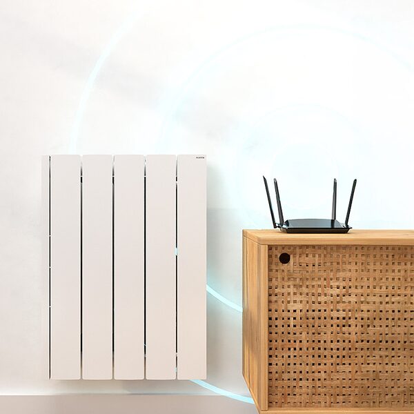 A white Rointe electric panel radiator mounted on a wall next to a rattan cabinet with a wifi router on top
