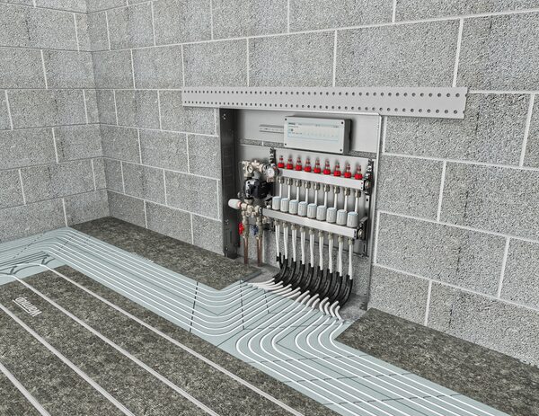 A Warmup underfloor heating manifold with wiring centre mounted in a recessed cabinet, with pipe loops running across the floor
