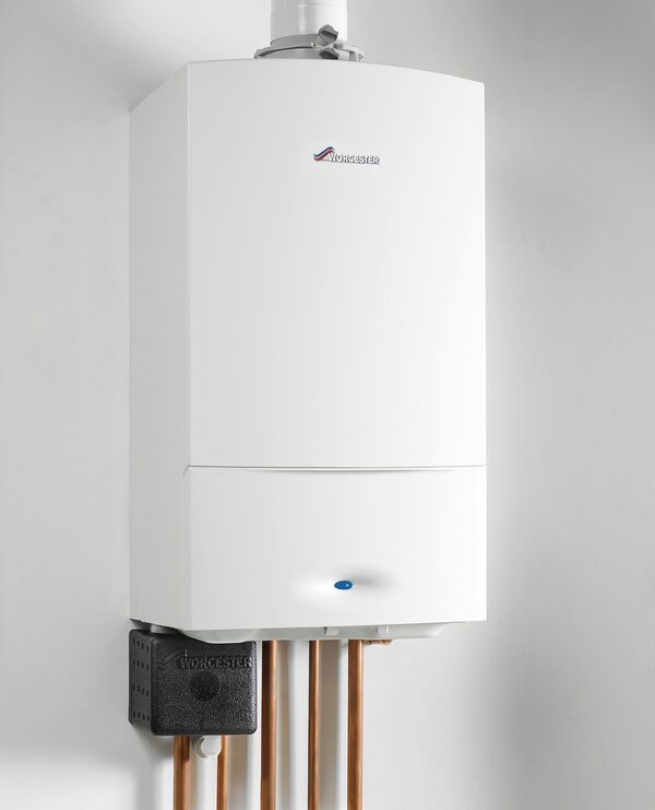 A white Worcester Bosch wall-mounted condensing gas boiler with copper pipework and a black CondensSure condensate pump fitted below