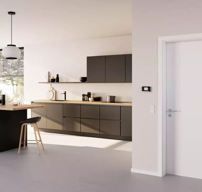 A WOLF wall-mounted heating control thermostat on the wall of a modern kitchen