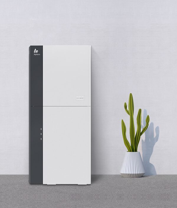 A white and grey AlphaESS SMILE-G3 home battery storage unit standing against a plain wall next to a potted cactus