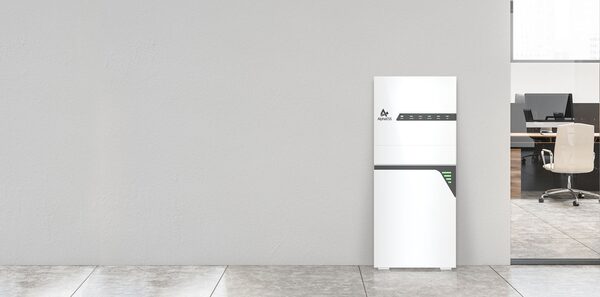 A white Alpha ESS SMILE-T10-HV wall-mounted home battery unit installed against a plain wall next to an office space