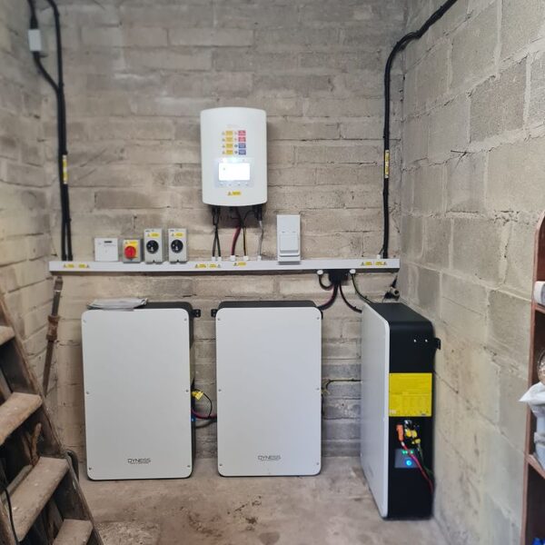 Three Dyness PowerBox home battery units installed on a bare brick wall with a Solis inverter and distribution board above them