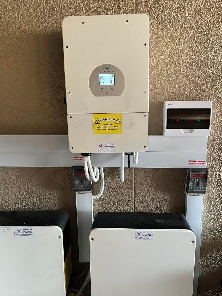 A Deye wall-mounted hybrid inverter installed above two Dyness Powerbox Pro home battery units on a wall