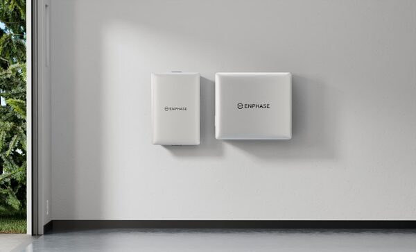 Two white Enphase home battery units mounted on a plain interior wall