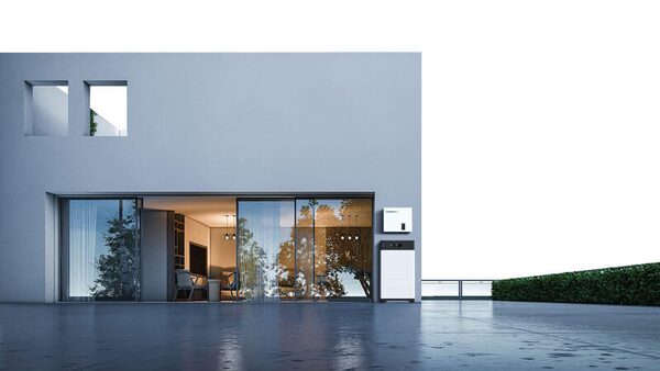 A Hanchu home battery unit and inverter mounted on the exterior wall of a modern house