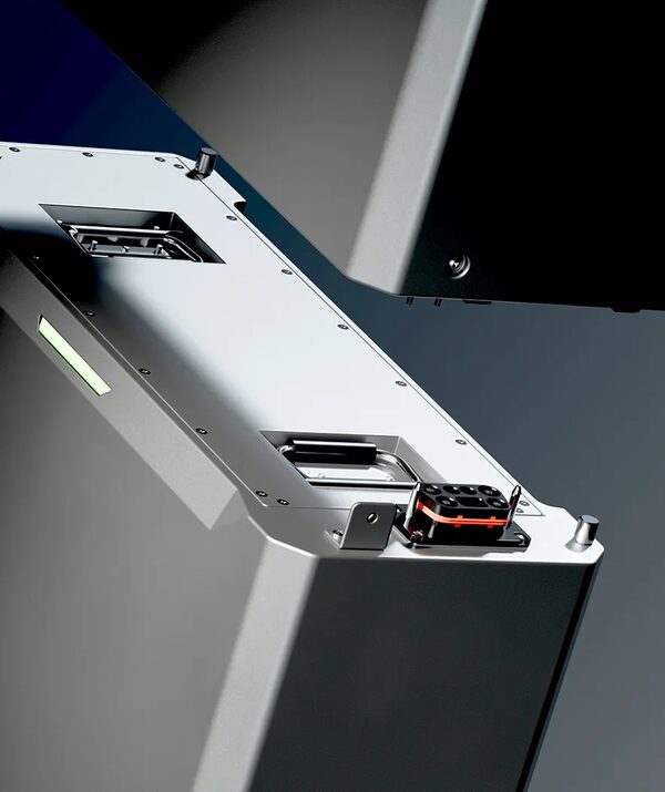 A close-up of a silver home battery unit with connection ports and a green status light